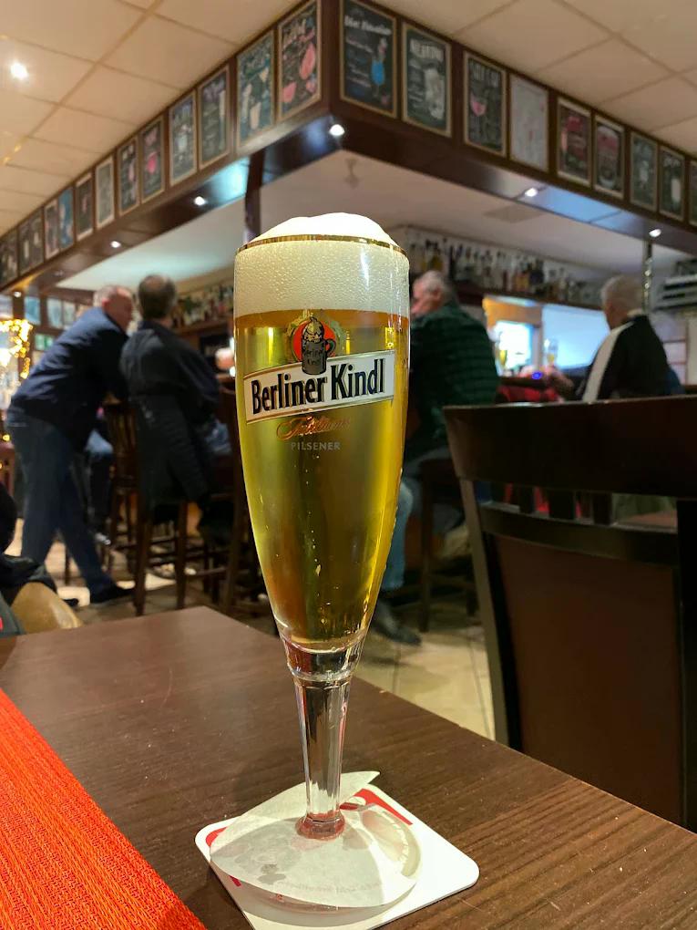 Ein frisch gezapftes blondes Bier im Berliner Kindl Glas steht im geselligen Pub